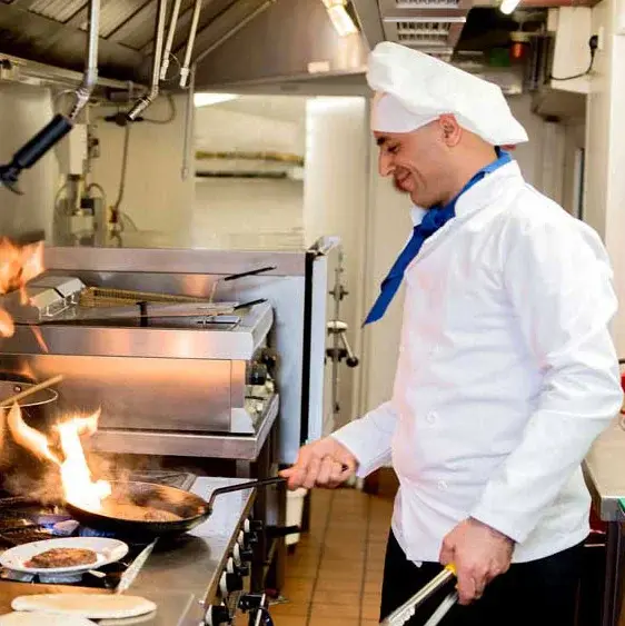 Magnolia Heights Chef Created Meals, chef frying a dish.