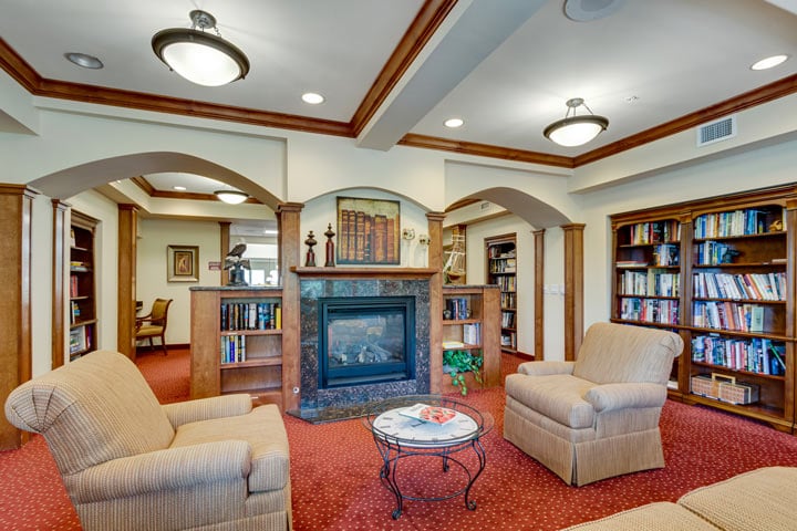 The library at Magnolia Heights with shelves of books and comfortable seating